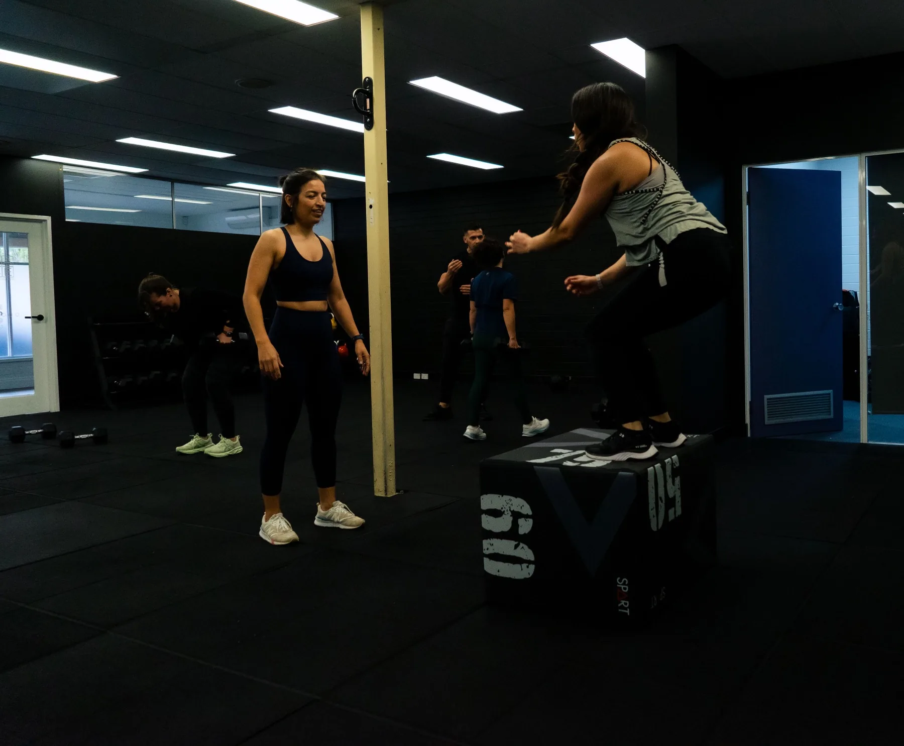 Client stepping down from a plyo box during training