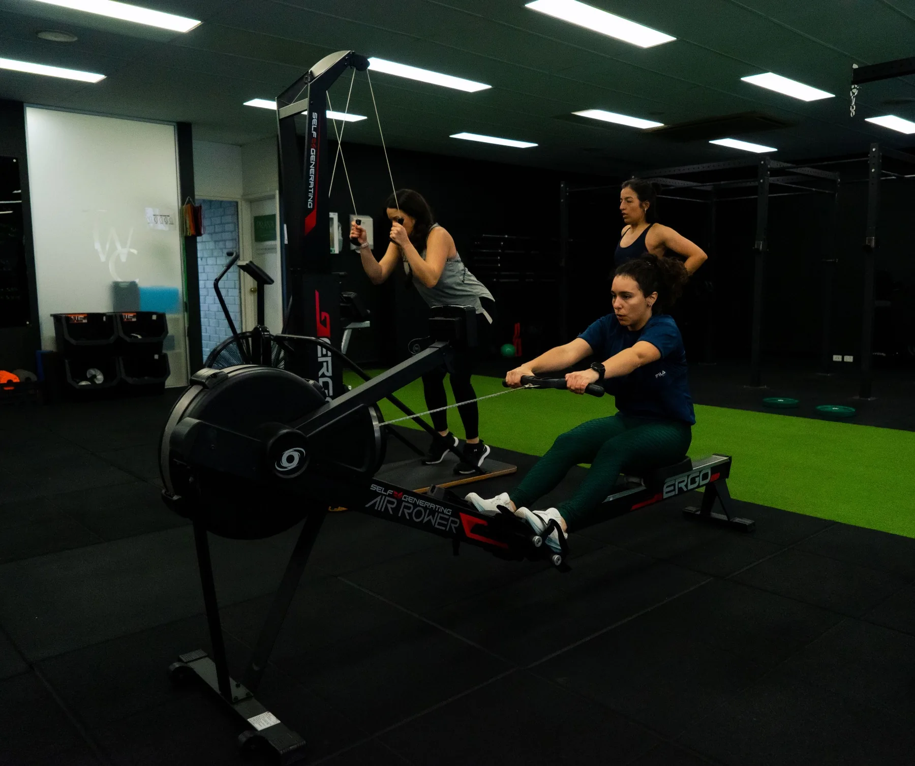 Clients training ski erg and rowing technique in the gym