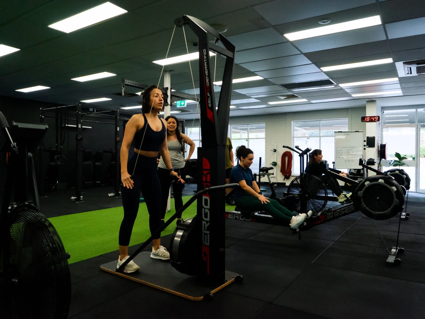 Client driving the ski erg during a group conditioning circuit