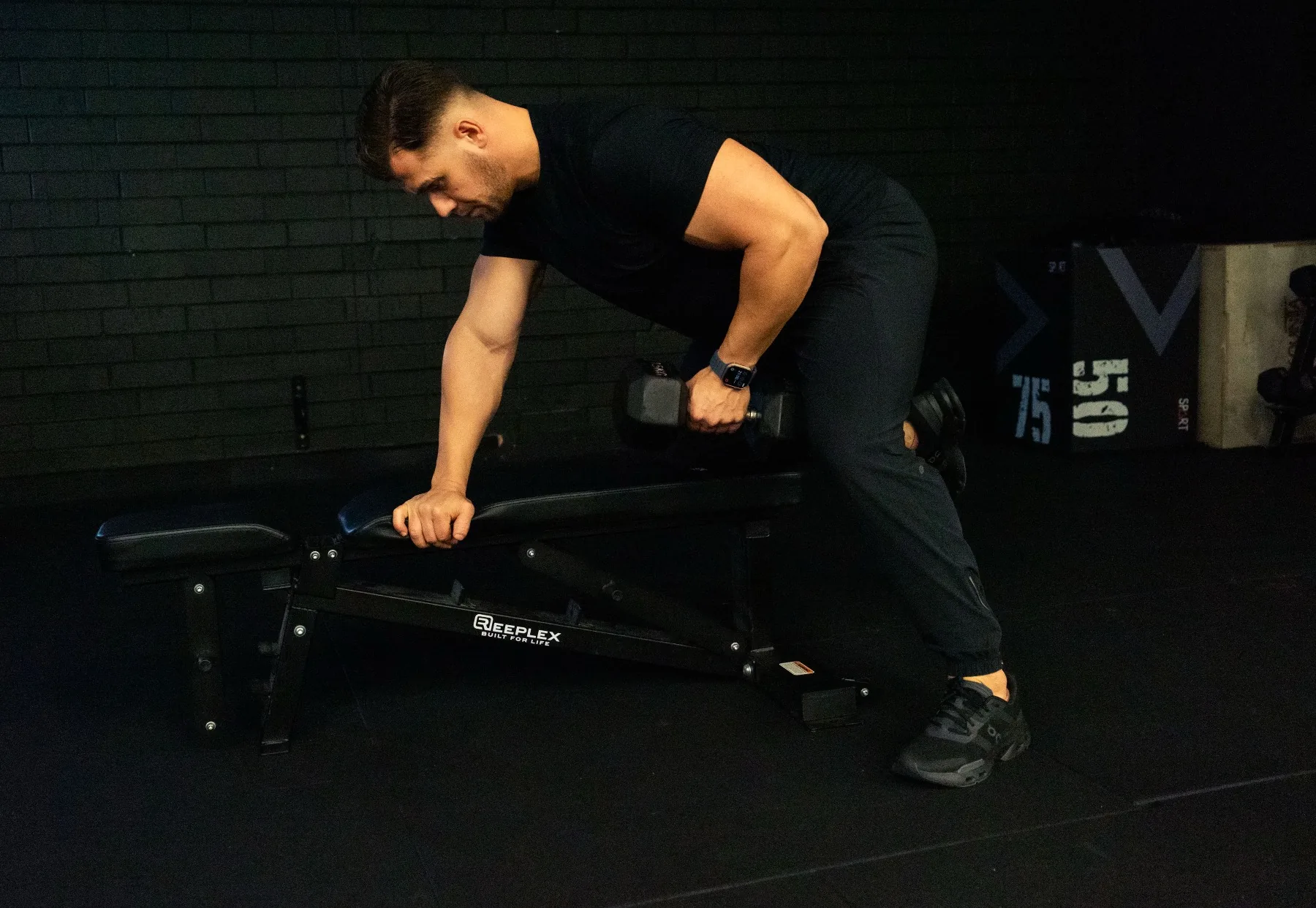 Hudson demonstrating a bench-supported dumbbell row