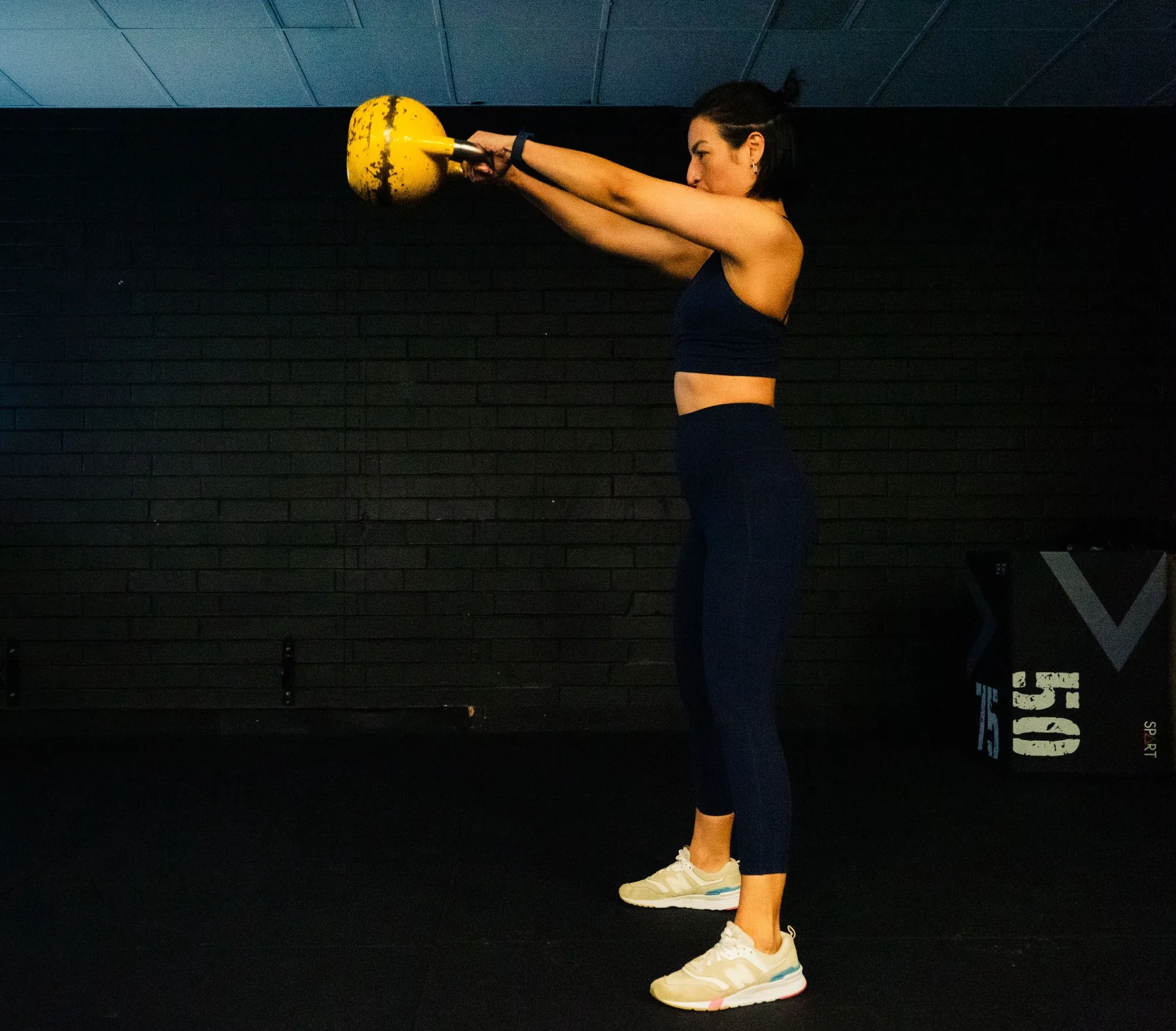 Client performing a kettlebell swing in training