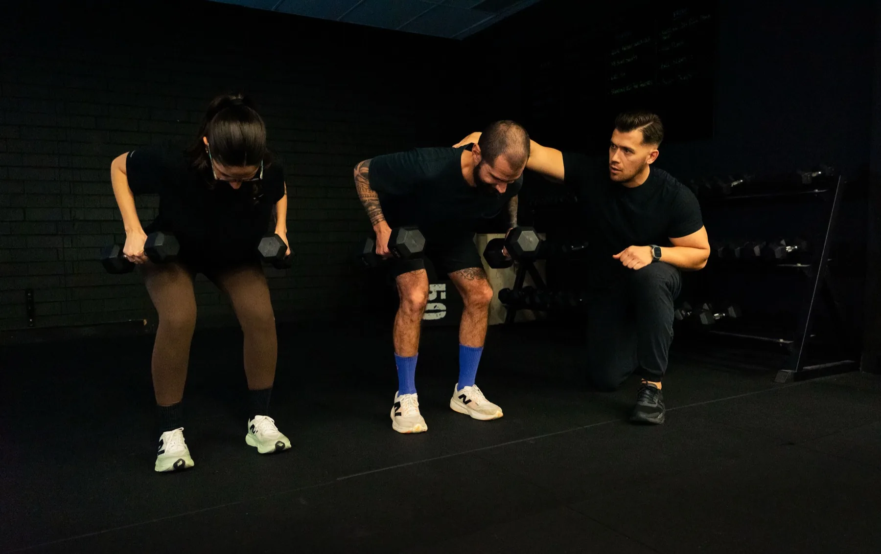 Hudson coaching clients during bent-over dumbbell rows