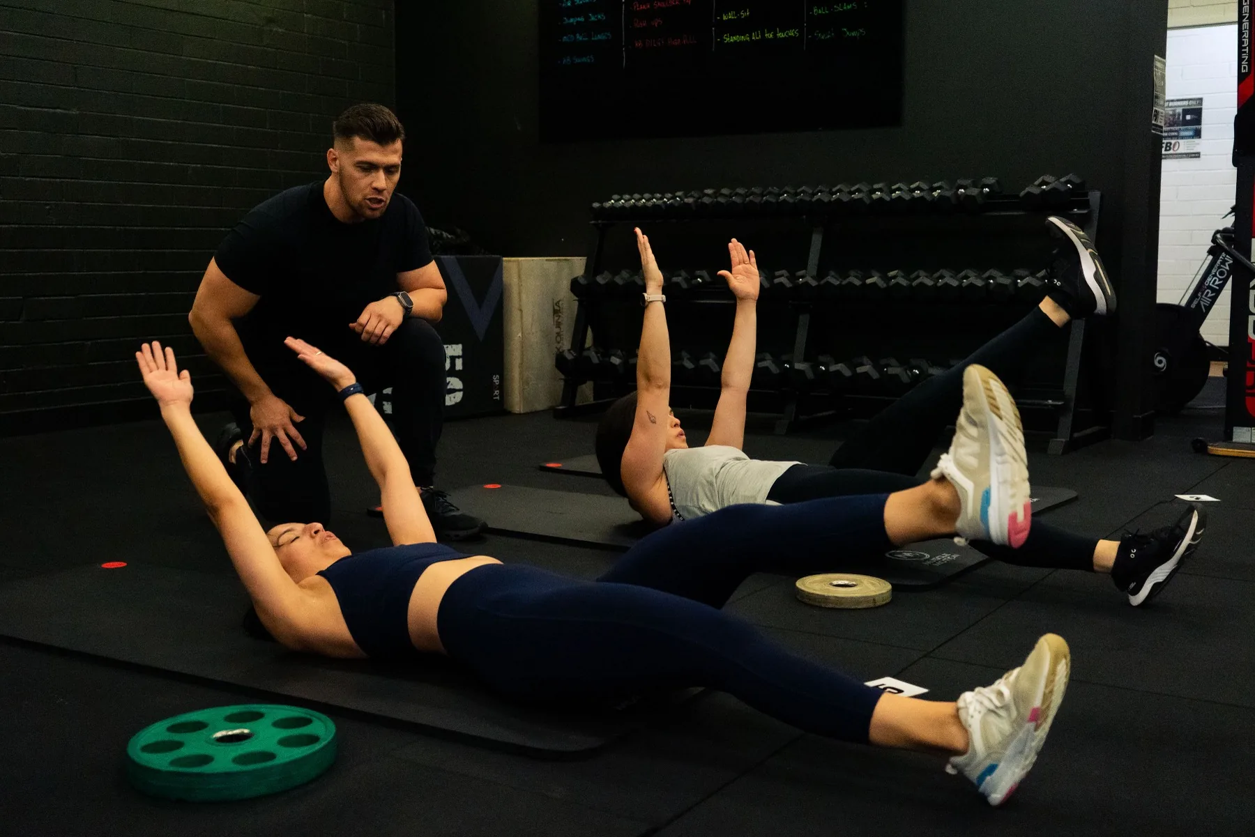 Hudson coaching clients through core floor work