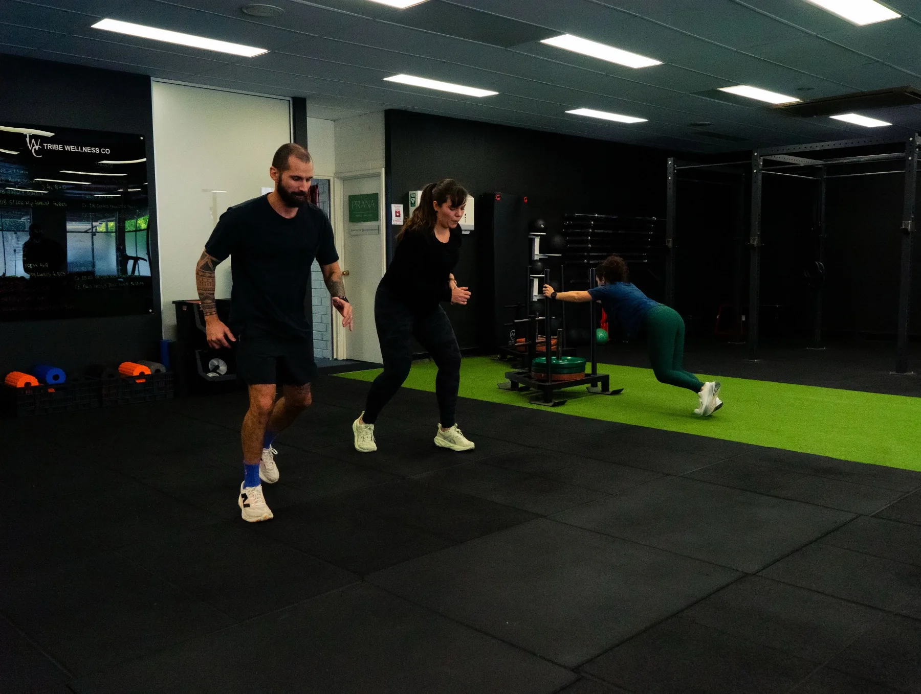 Clients performing weighted core work on mats