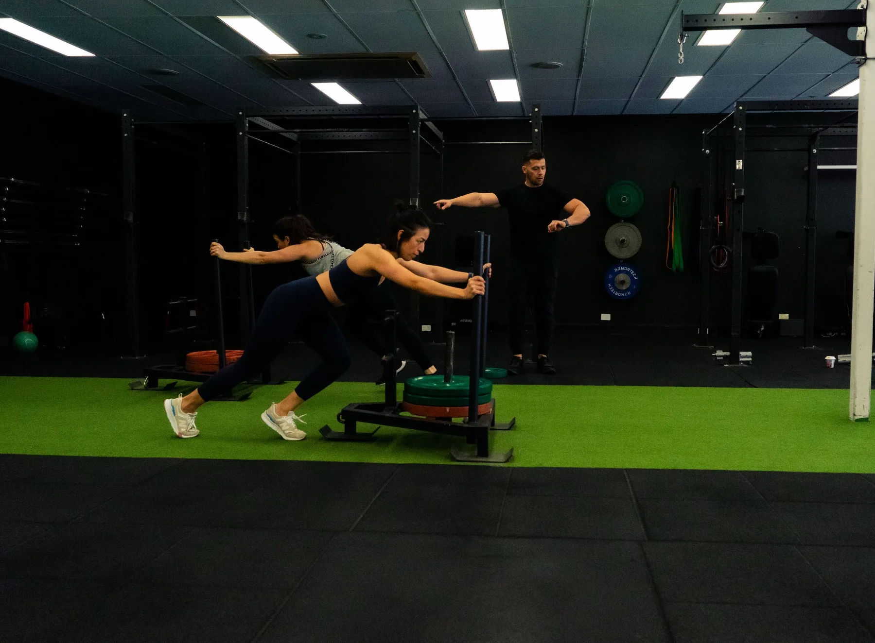 Client driving a weighted sled while Hudson coaches form
