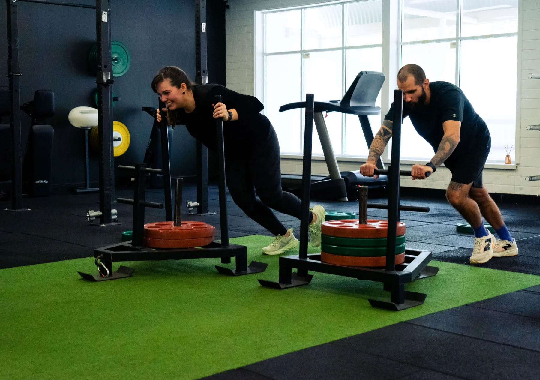 Clients pushing loaded sleds during a conditioning session