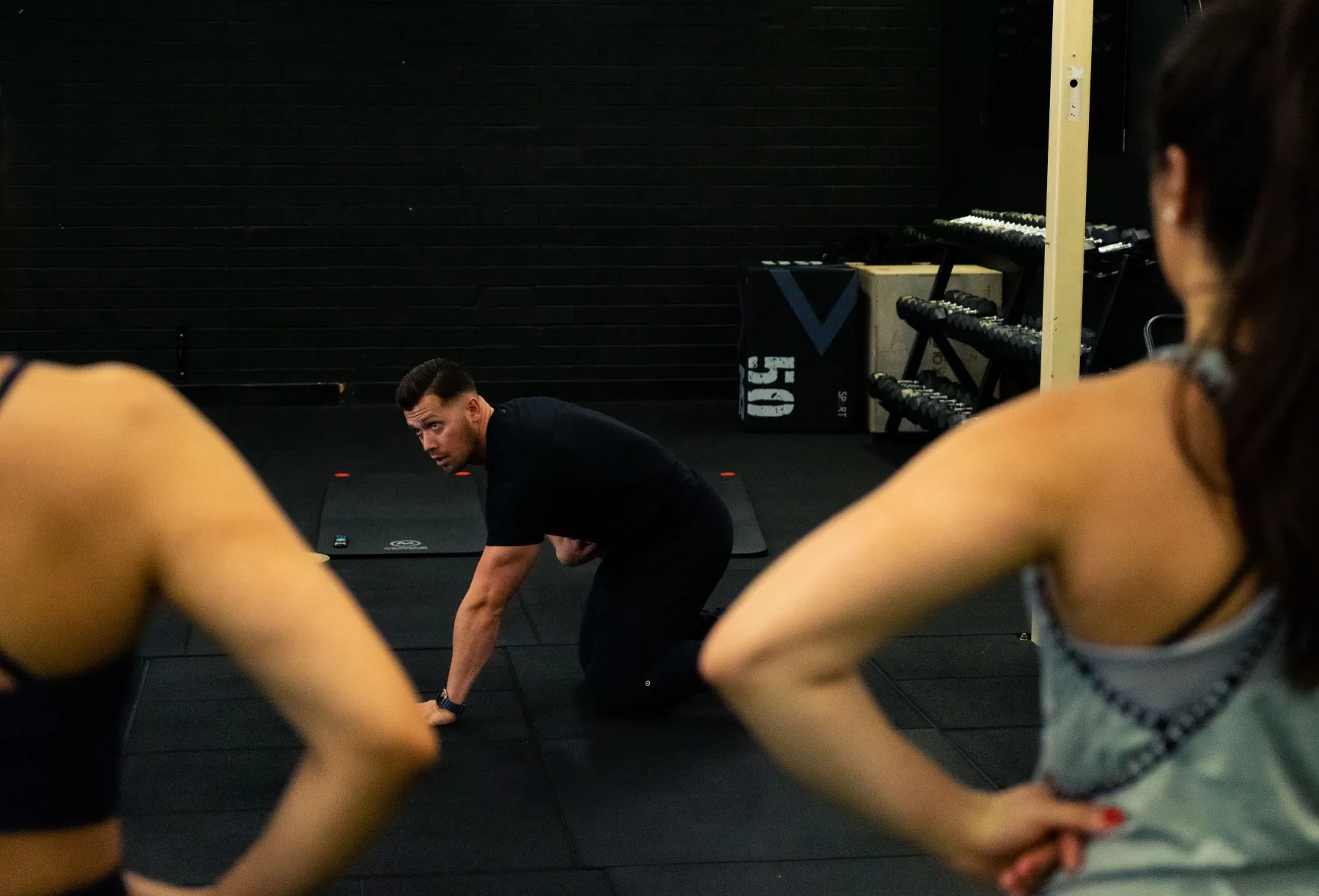 Hudson coaching clients from the floor during conditioning