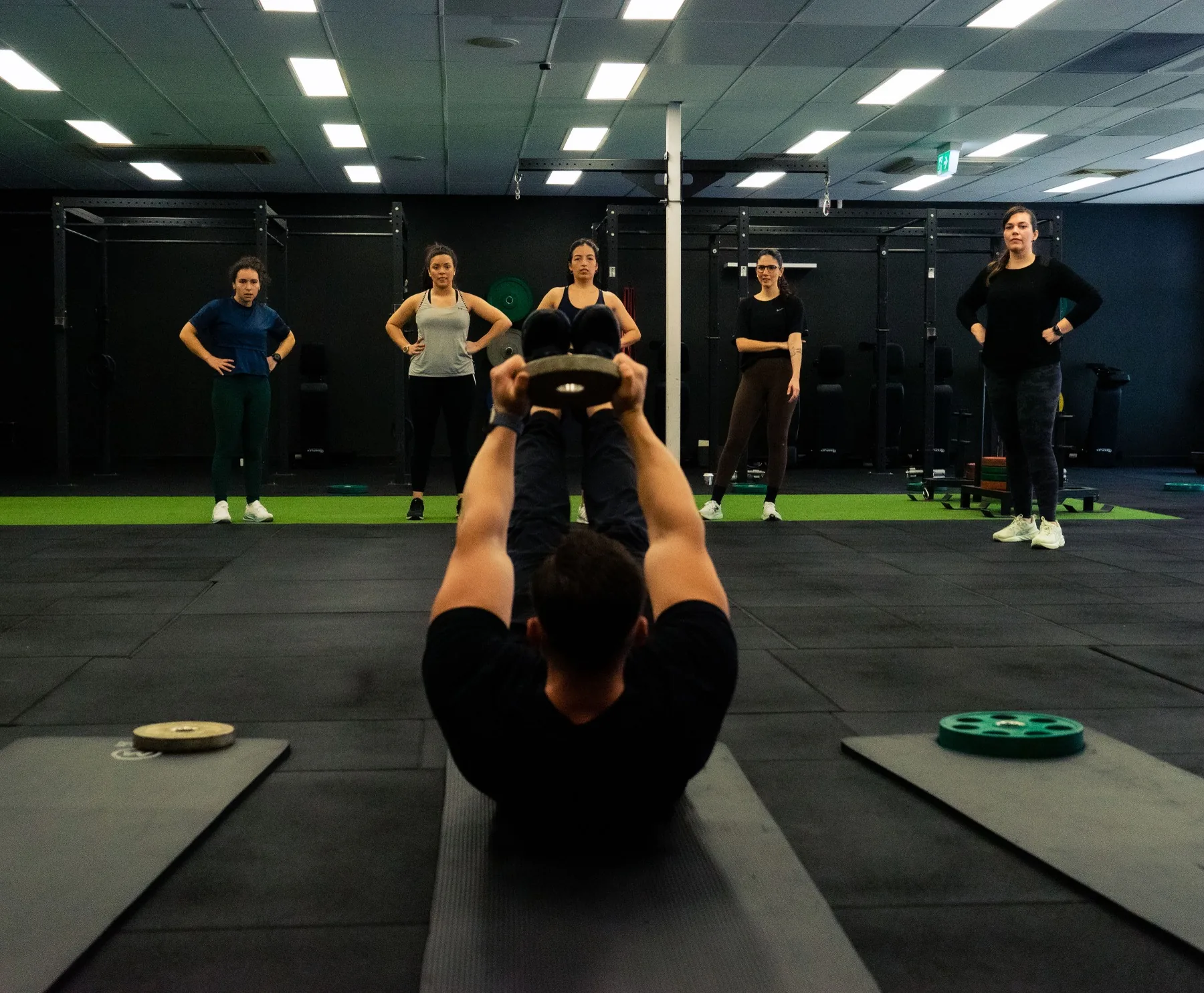 Hudson demonstrating weighted floor work to a small group