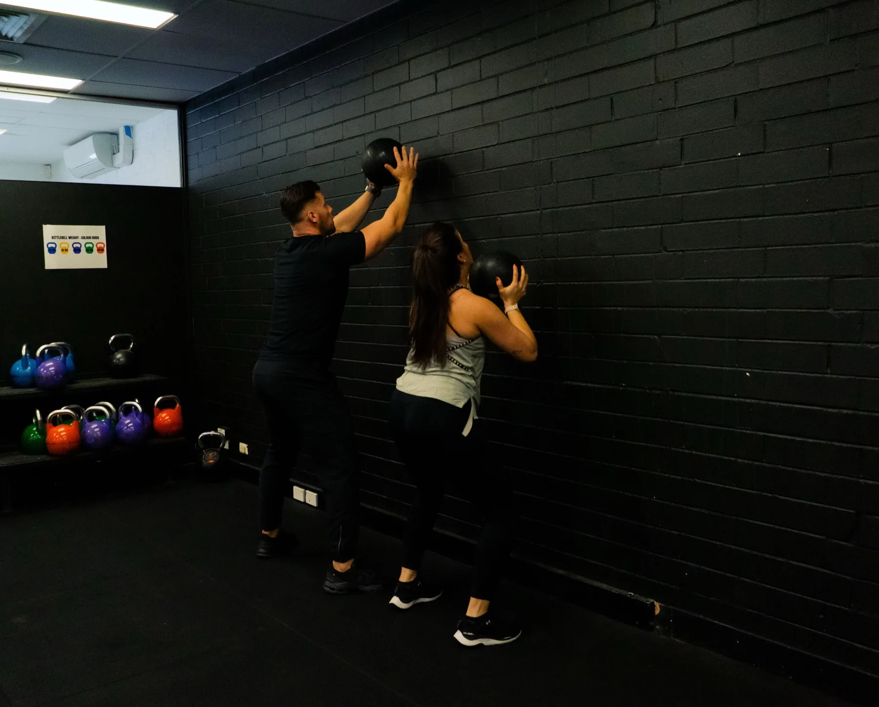 Hudson assisting a client with wall ball technique