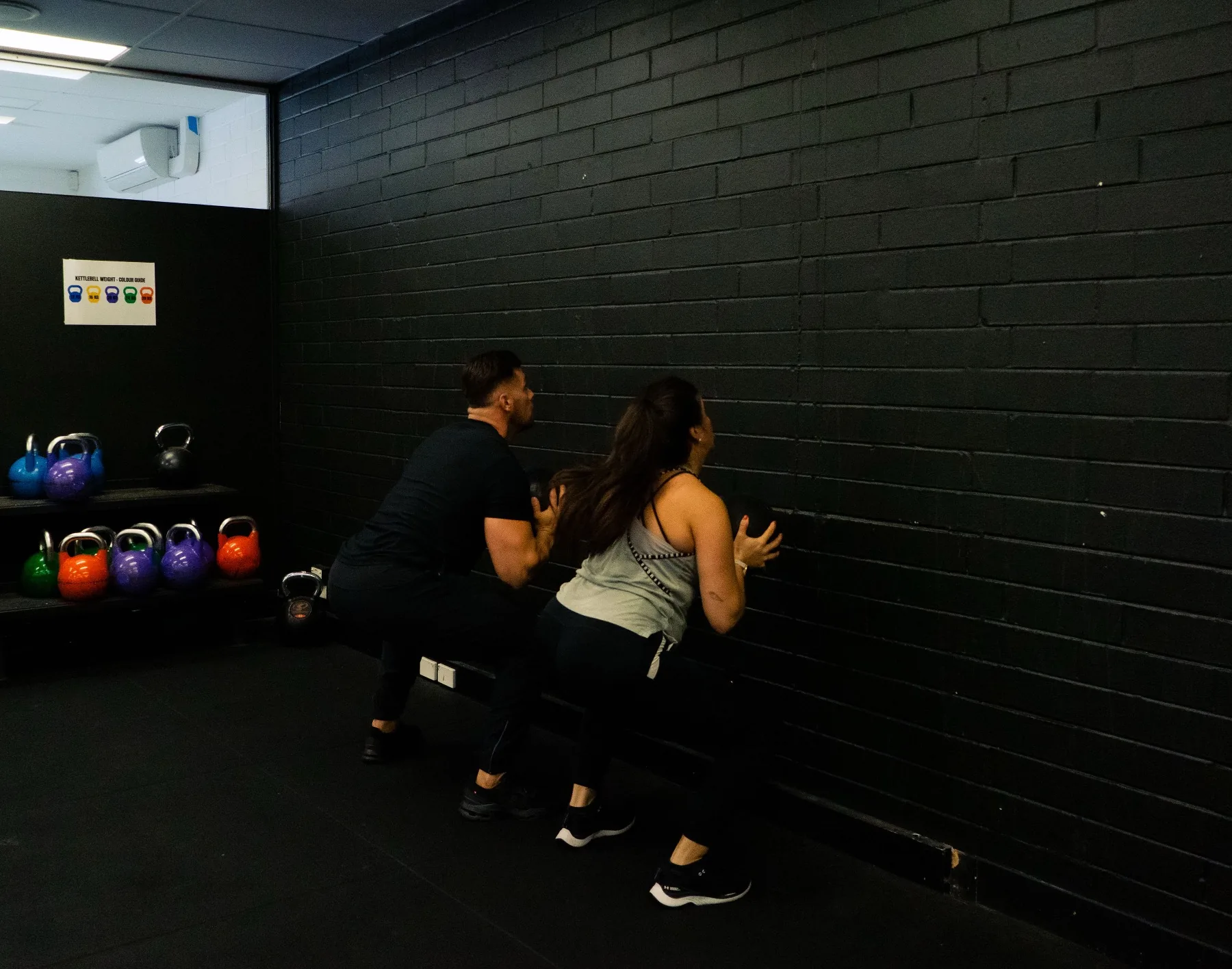 Client performing a wall ball throw under Hudson's guidance