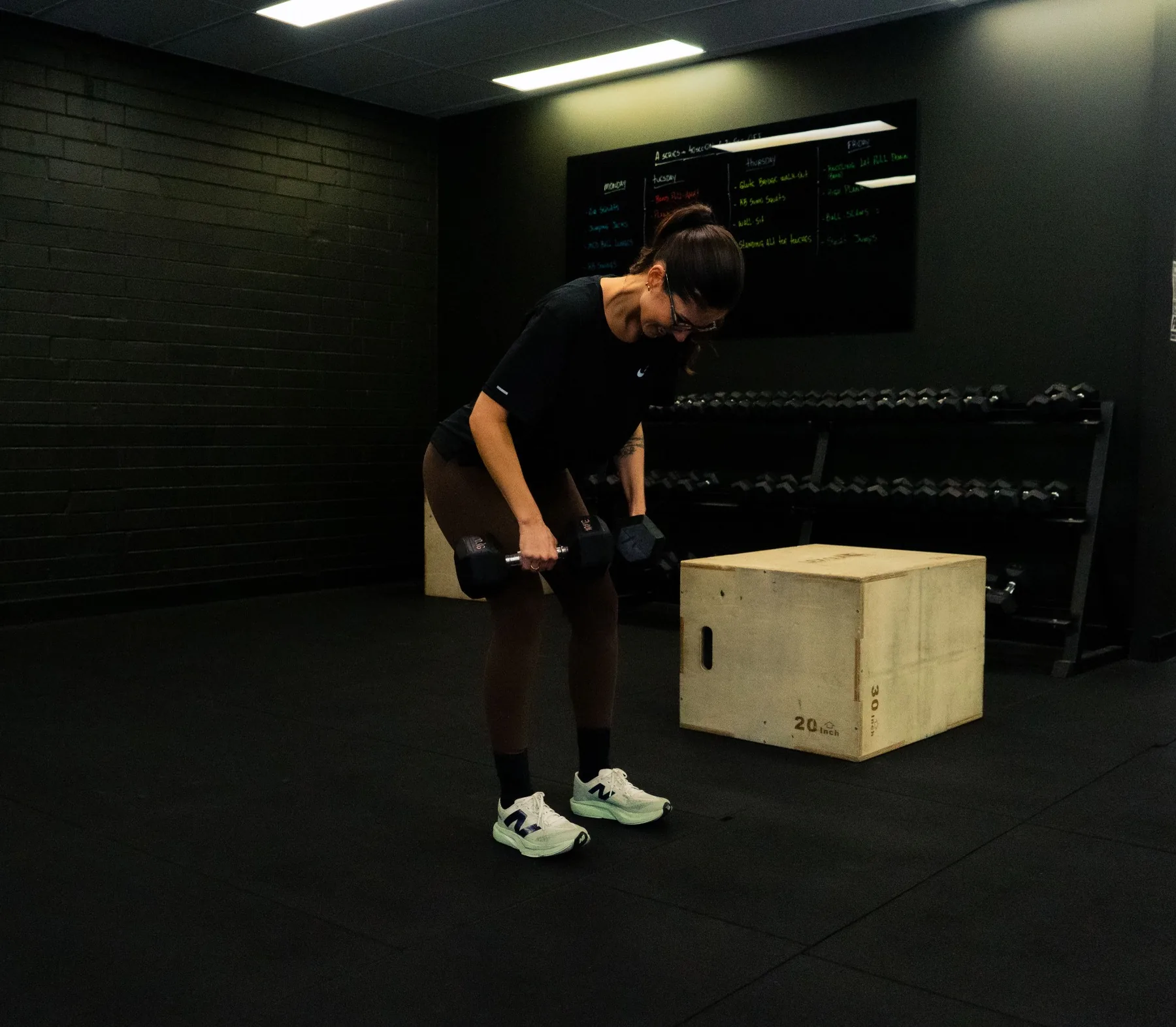 Client continuing a dumbbell row set with focused form