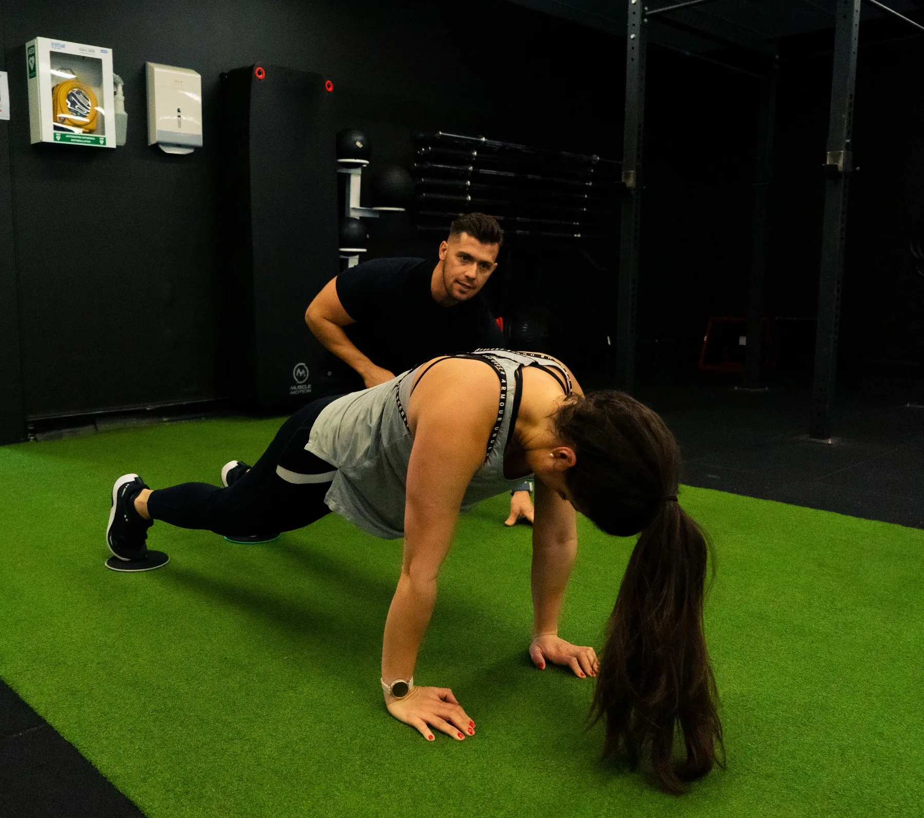 Hudson coaching a client through a bear crawl drill