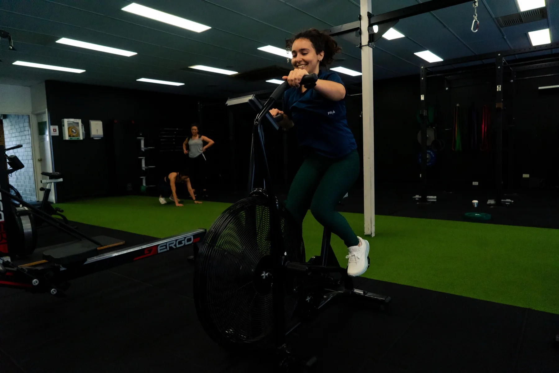 Client pushing through an air bike interval in the gym