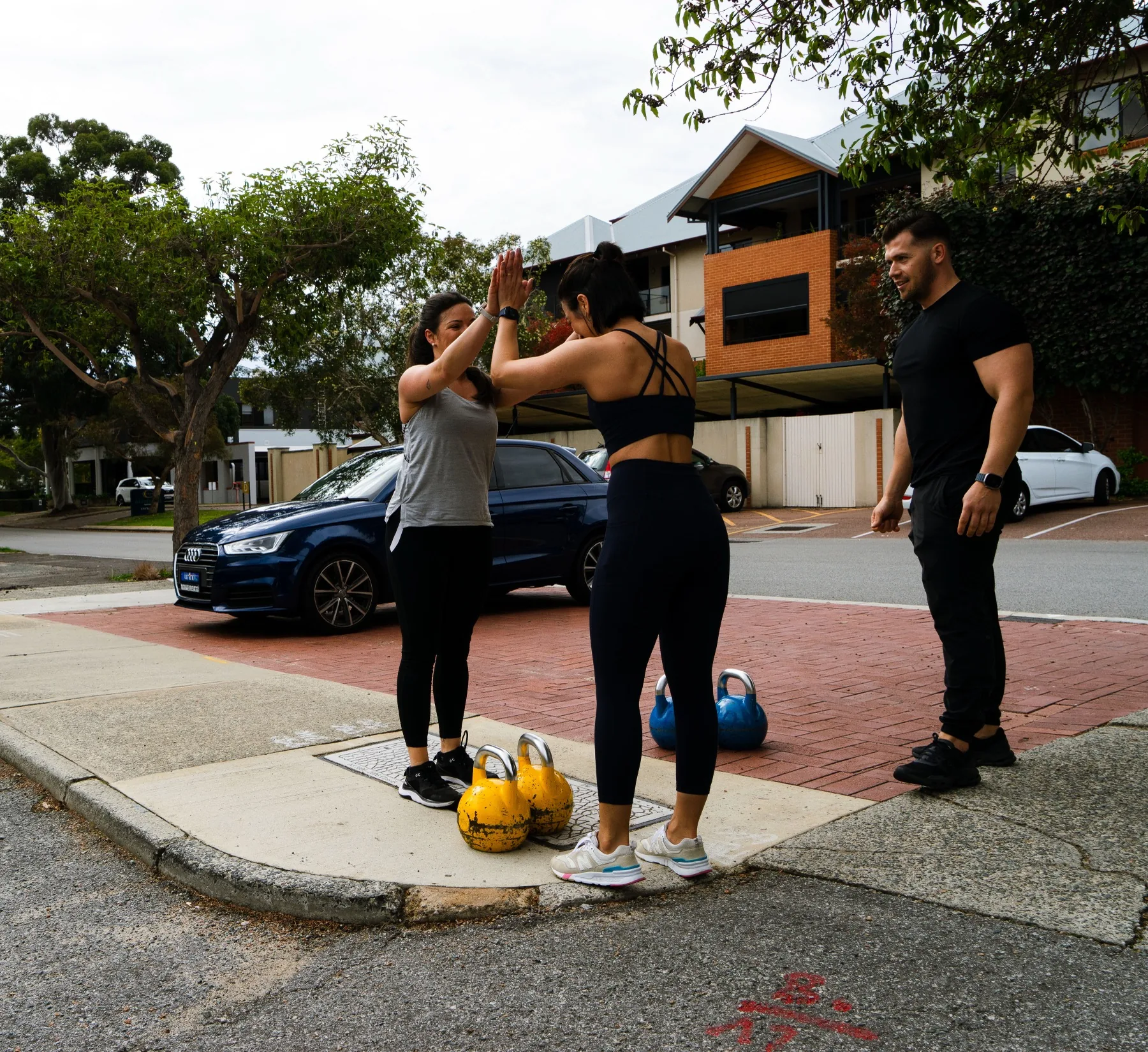 Clients celebrating outdoors after a kettlebell carry
