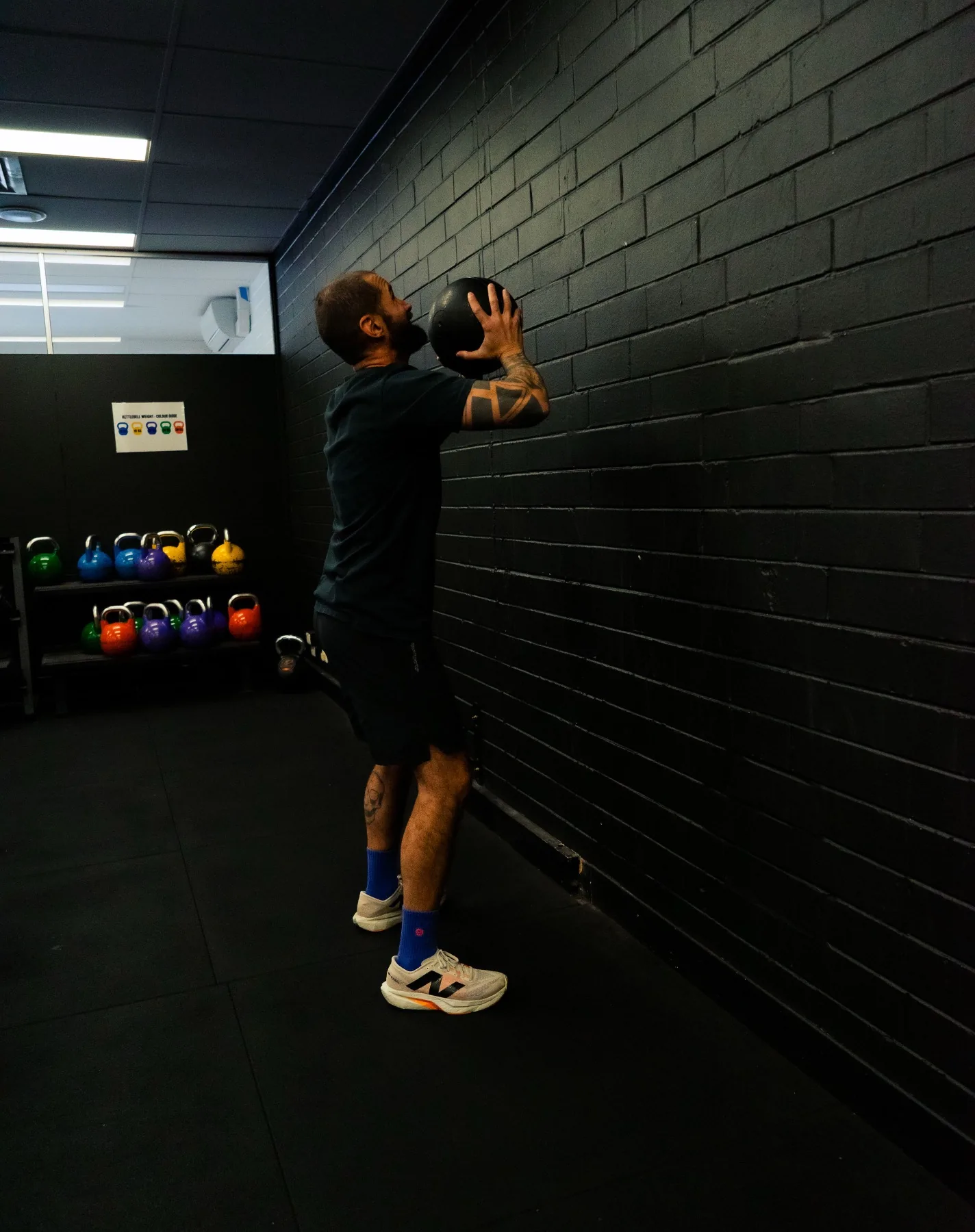 Client setting up for a wall ball toss in the gym