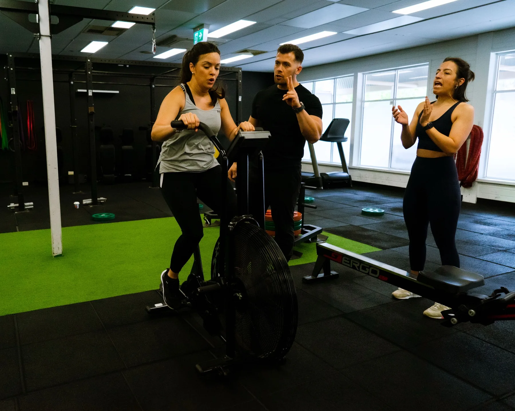 Client pushing an air bike interval with Hudson counting reps