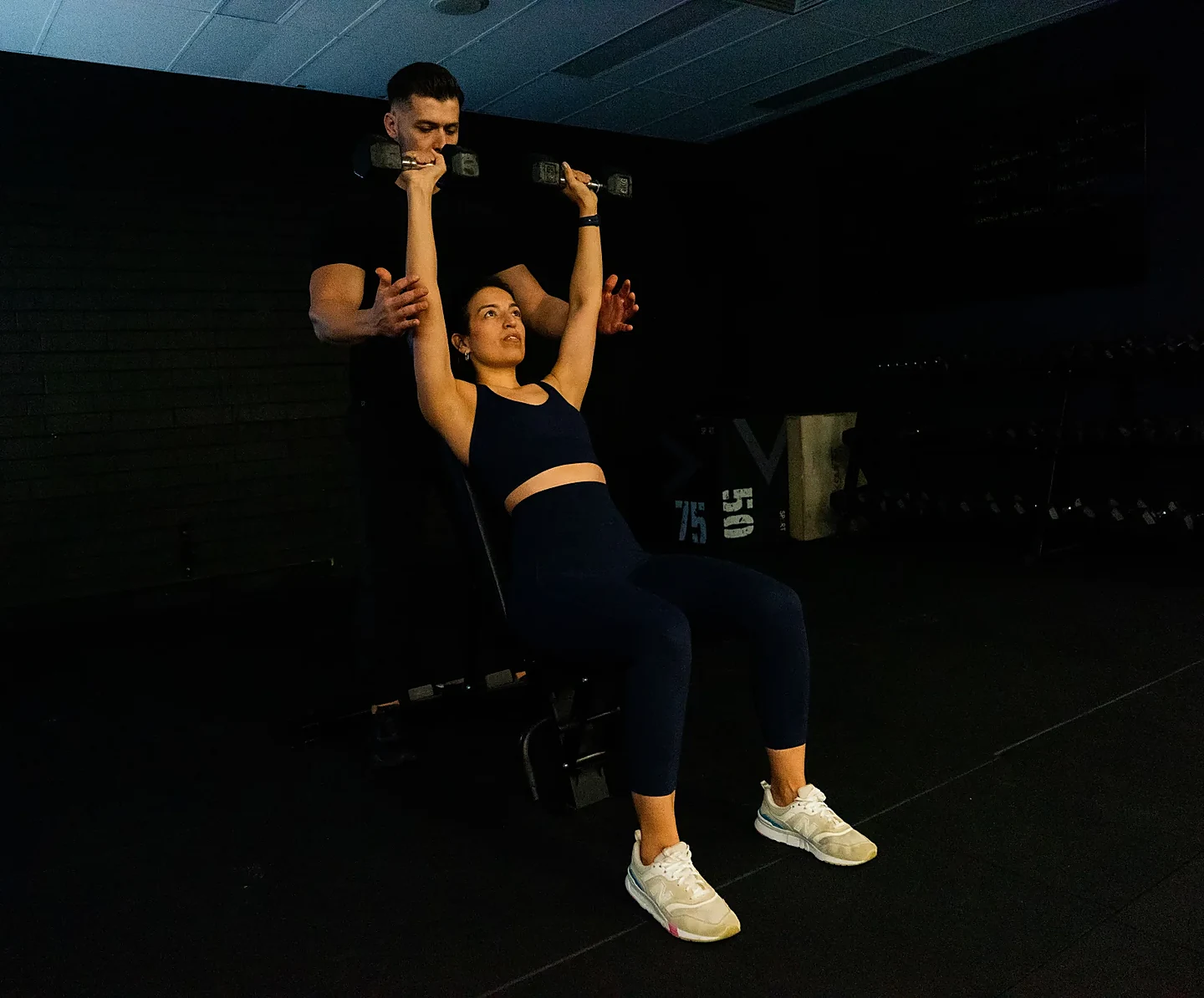 Hudson guiding a client through dumbbell shoulder work